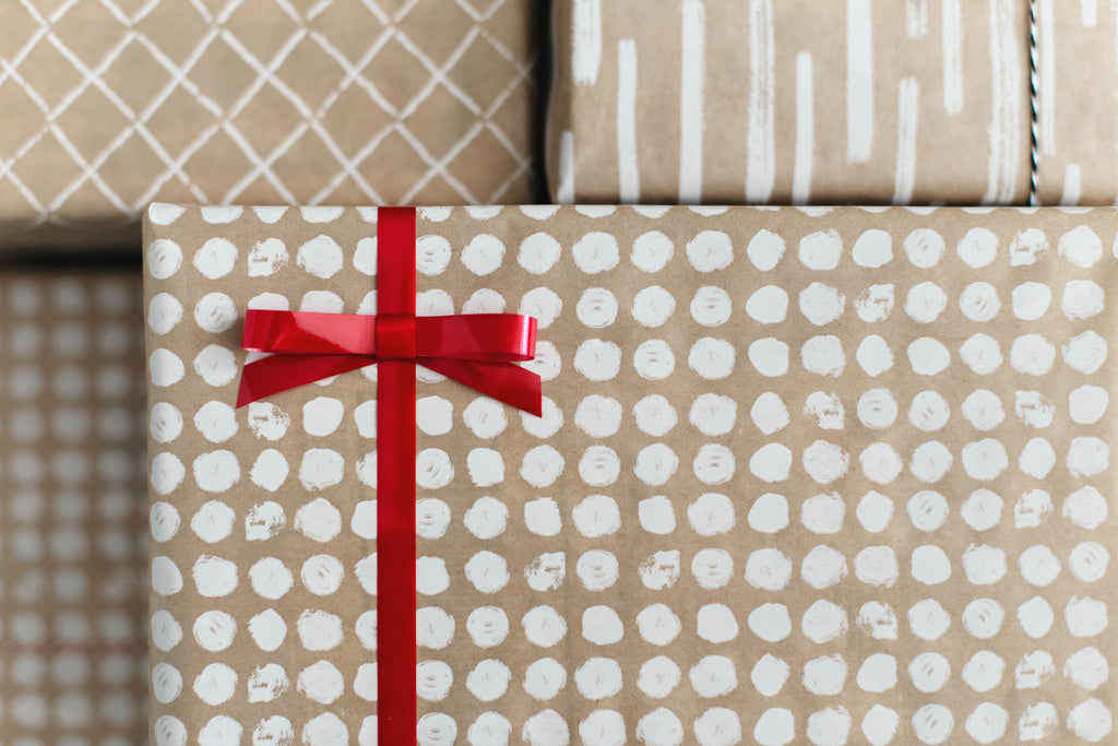 Gifts Wrapped in Brown/White Wrapping Paper & Red Ribbon Bow