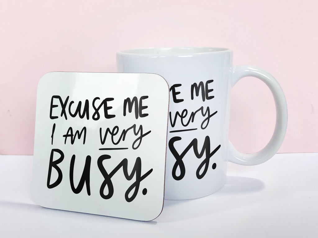 An 11oz ceramic mug reading "Excuse Me I Am Very Busy" with a matching coaster